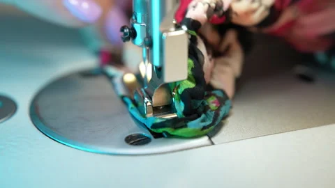 Sewing needle with thread moving up and down making seam on colourful fabric Stock Footage 250018651