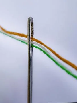 Sewing Needle Threaded with Saffron White and Green Threads Foto stock