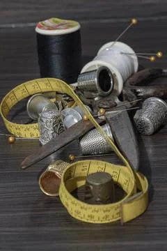 Sewing needles, Thimbles, Scissors, Measuring tape, Buttons, Spools of blac.. Stock Photos