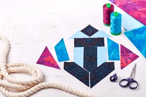 Sewing patchwork of block anchor, spools of threads, fabrics, rope lie on w.. Stock-Fotos