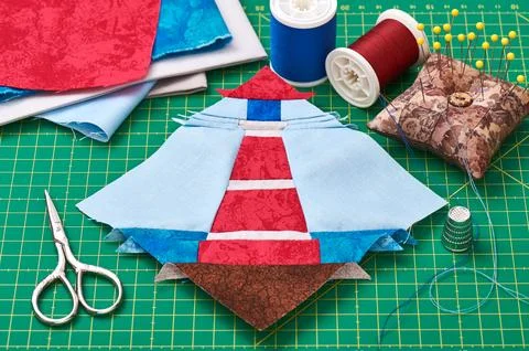 Sewing patchwork of block of lighthouse surrounded by accessories Fotos de archivo