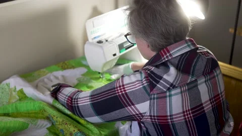 Sewing a pattern through the layers of a quilt using a sewing machine Stock Footage 171453557