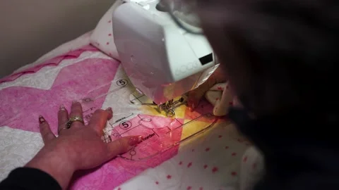 Sewing a patterning on a handmade quilt using a sewing machine and a Stock Footage 168421125
