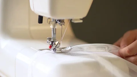 Sewing process. The seamstress files transparent curtains on a sewing machine Stock Footage 125938502