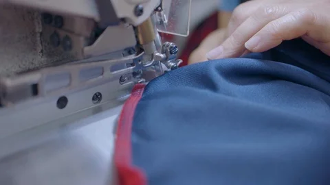 Sewing red seams onto blue shirt Видео 123725832