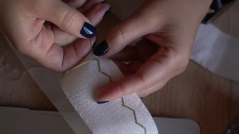 Sewing a simple ribbon design by hand while sitting at a table Video stock 329559834