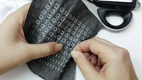 Sewing square pattern by hand needle and thread macro Video stock 330050574