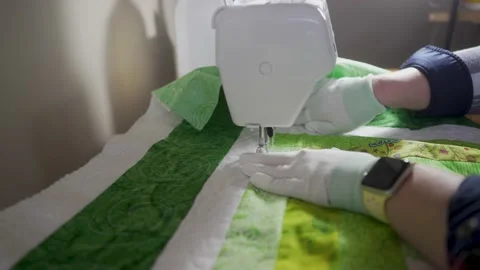 Sewing in a stitch pattern through all the layers of a patchwork log-cabin Stock Footage 171453510