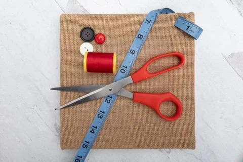 Sewing supplies red thread spool scissors blue tape measure Stock Photos
