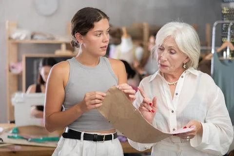 Sewing teacher reviewing pattern with student during class Stock Photos