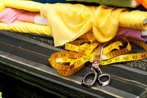 Sewing textile or cloth. Work table of a tailor. Scissors, measuring tapes. Top Stock Photos