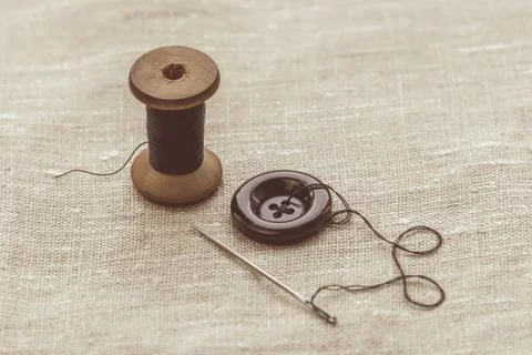 Sewing thread and for knitting? the gray thread and the needle and the button Stock Photos