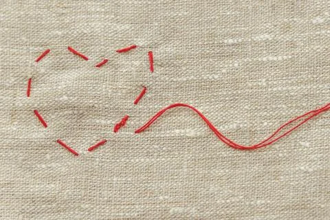 Sewing thread and for knitting, a red string in the form of a medical heart o Stock Photos