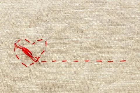 Sewing thread and for knitting, a red string in the form of a medical heart o Stockfoto's