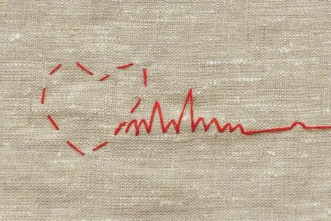 Sewing thread and for knitting, a red string in the form of a medical heart o Stock Photos