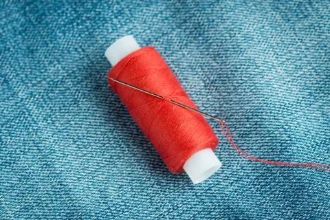 Sewing thread and needle closeup Stock Photos