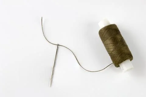 Sewing thread and needle Stock Photos