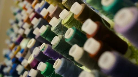 Sewing thread of cool colors in the coils hanging on the wall. Indoors, natural Stock Footage 80308305