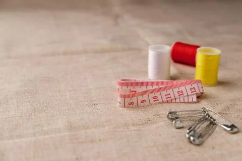 The sewing thread is next to the sewing tape and pins. Stock Photos