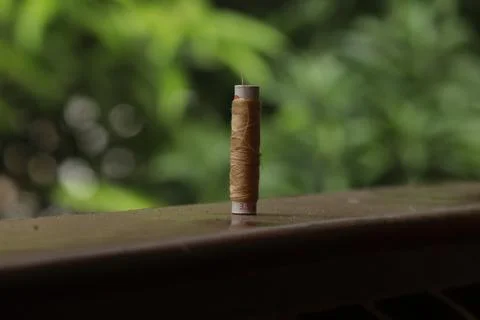 A sewing thread placed on a dusty floor Stock Photos