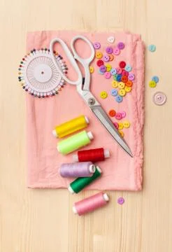 Sewing thread, threads, pieces of cloth, buttons on wooden table Stock Photos