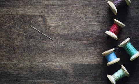 Sewing thread on a wooden background. Set of threads on bobbins Stock Photos