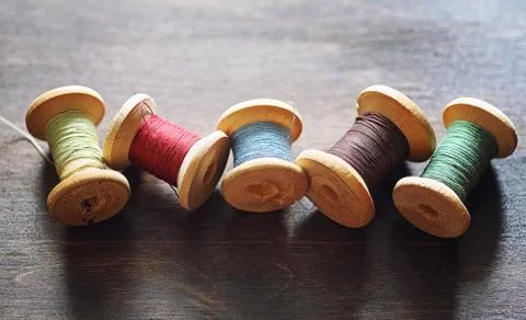 Sewing thread on a wooden background. Set of threads on bobbins 写真素材
