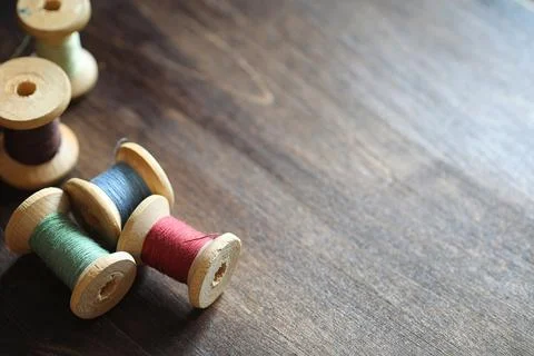 Sewing thread on a wooden background. Set of threads on bobbins retro style.. Stock Photos