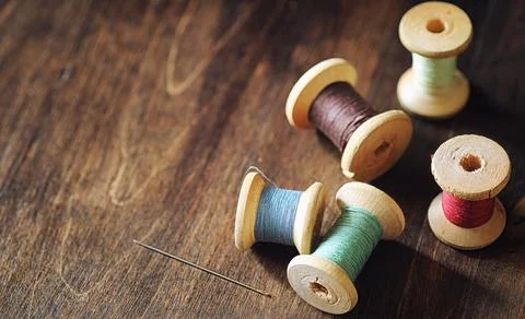 Sewing thread on a wooden background. Set of threads on bobbins retro style.. 写真素材