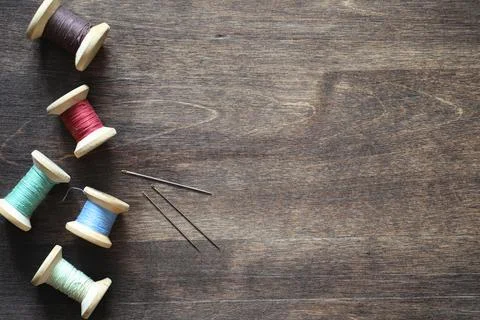 Sewing thread on a wooden background. Set of threads on bobbins retro style.. Stock Photos