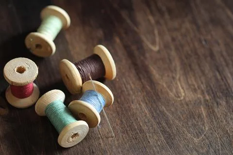 Sewing thread on a wooden background. Set of threads on bobbins retro style.. Stock Photos