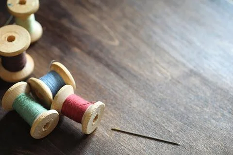 Sewing thread on a wooden background. Set of threads on bobbins retro style.. Stock Photos