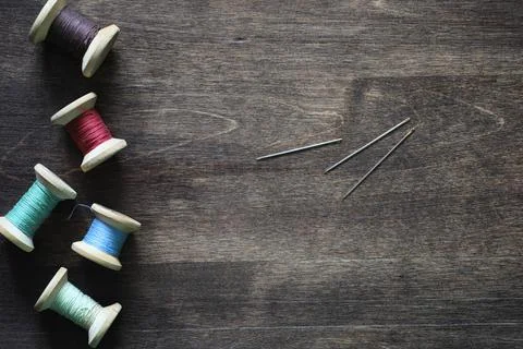 Sewing thread on a wooden background. Set of threads on bobbins retro style.. Stock Photos