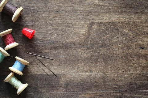 Sewing thread on a wooden background. Set of threads on bobbins retro style.. Stock Photos
