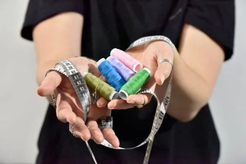 Sewing threads and measuring tape in female hands Stock Photos