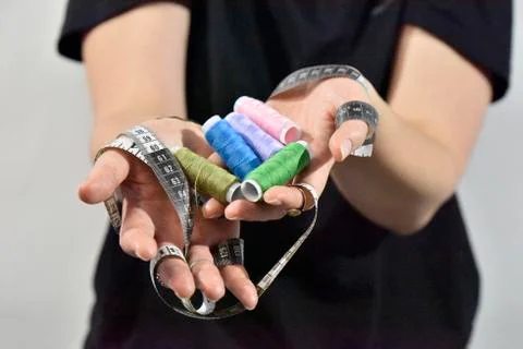 Sewing threads and measuring tape in female hands Stock Photos