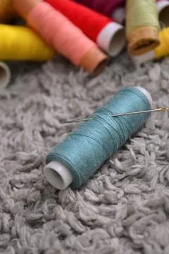 Sewing threads and a needle Stock Photos