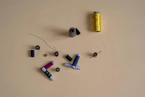 Sewing threads and needles studio shot. Fashion concept on a yellow background. Stock Photos