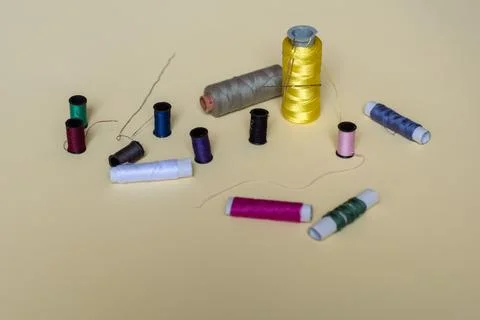 Sewing threads and needles studio shot. Fashion concept on a yellow background. Stock Photos