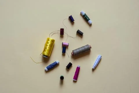 Sewing threads and needles studio shot. Fashion concept on a yellow background. Stock Photos