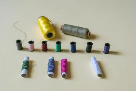 Sewing threads and needles studio shot. Fashion concept on a yellow background. Photos