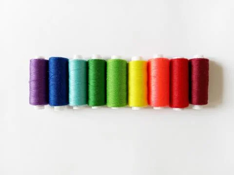 Sewing threads arranged in rainbow order on white background Stock Photos
