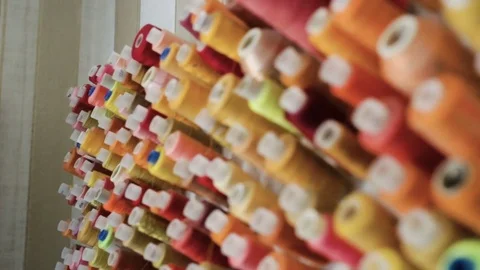 Sewing threads of different colors on the coils hanging on the wall Stock Footage 80275927