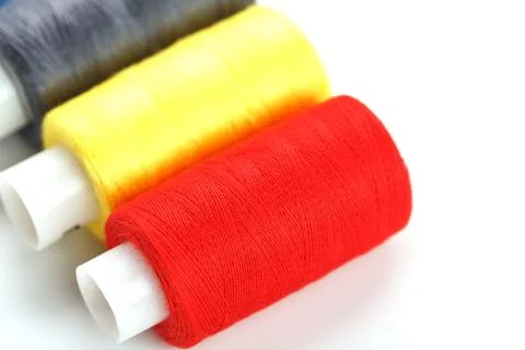Sewing threads of different colors on reels on a white background. Free spa.. Stock Photos