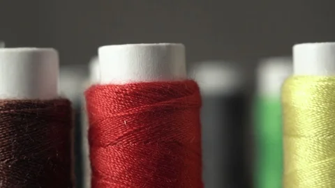 Sewing Threads On Spool. Extreme Closeup. Colorful spools of thread in textile Stock Footage 128994081