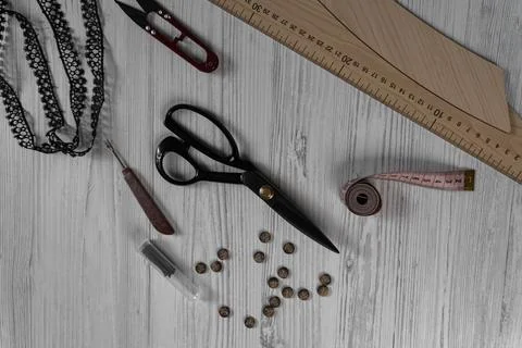 Sewing tools and accessories on table with scissors threads buttons and mea.. Foto stock
