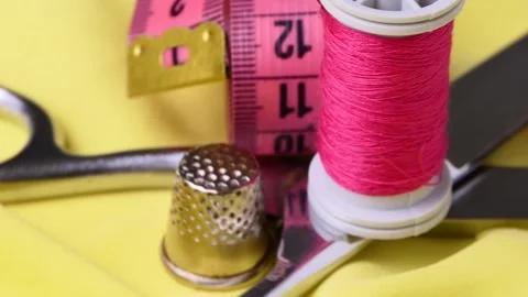 Sewing tools and threads rotate on a board Stock Footage 248387642