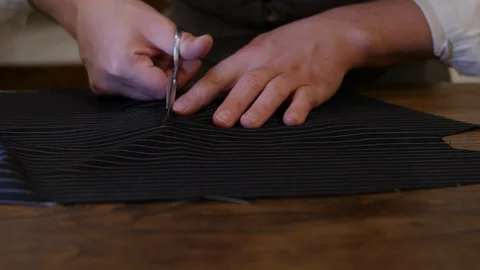 Sewing tools. Close-up: the scissors cuts the tissue. Seamstress keeps the Stock Footage 127231630