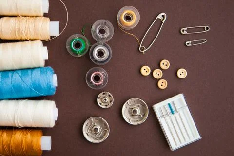 Sewing tools on the dark brown background with copy space Stock Photos