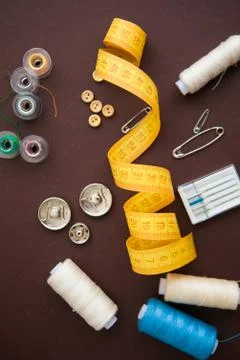Sewing tools on the dark brown background with copy space Stock Photos